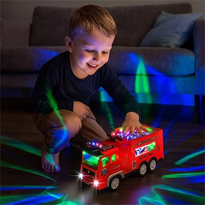 camion pompier jouet lumineux dans le noir avec petit garçon