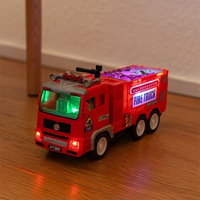 camion pompier jouet lumineux rouge par terre