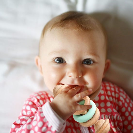 bebe utilisant hochet bois silicone pour soulager les gencives