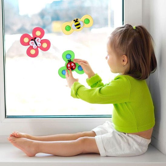 jouet de bain tournibain sur une fenetre avec petite fille