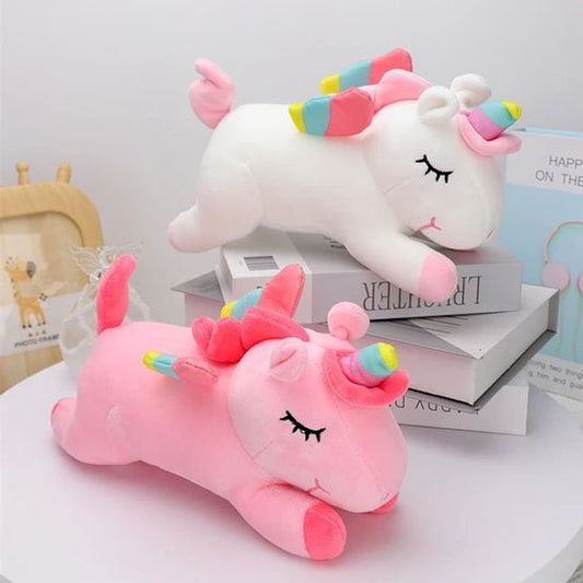 Licorne peluche rose et blanc sur des livres