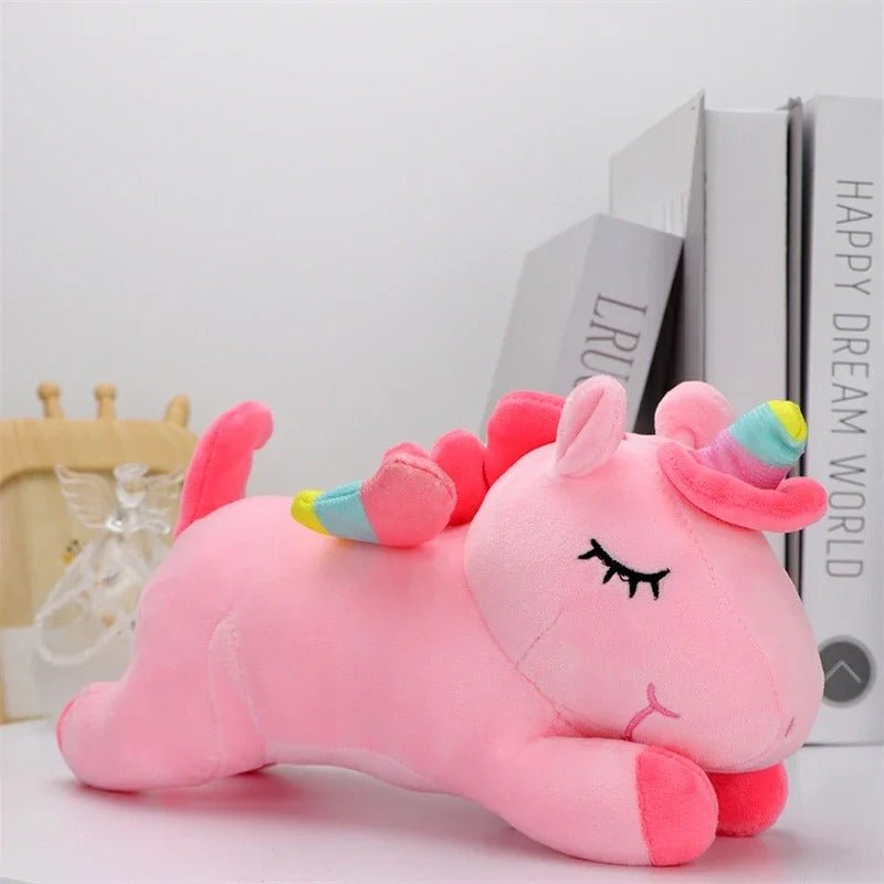 Licorne peluche rose devant des livres