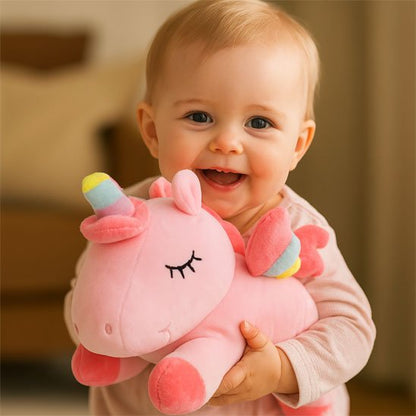 Licorne peluche rose et petit garçon qui fait un grand sourire